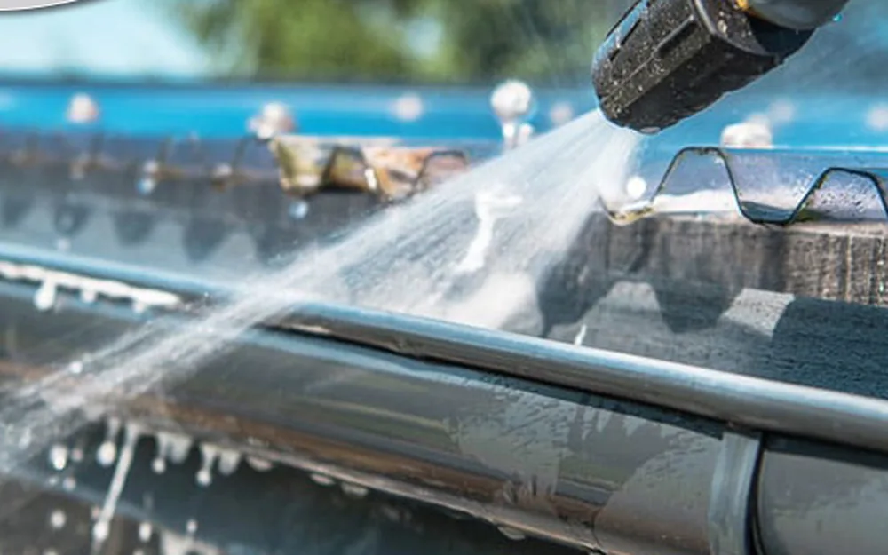 Technician clearing gutters
